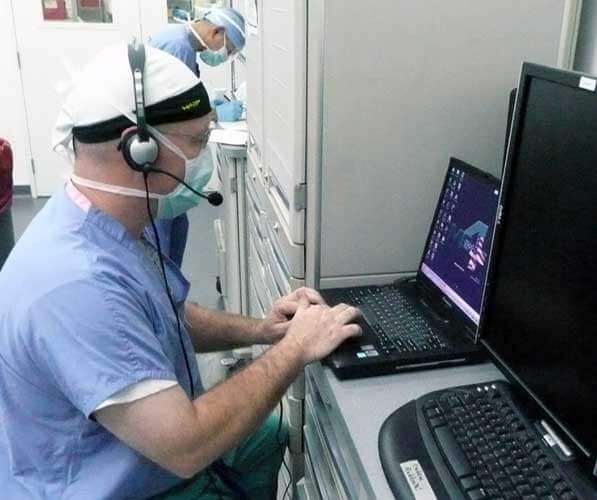 doctor sitting at computer entering information into an electronic medical record